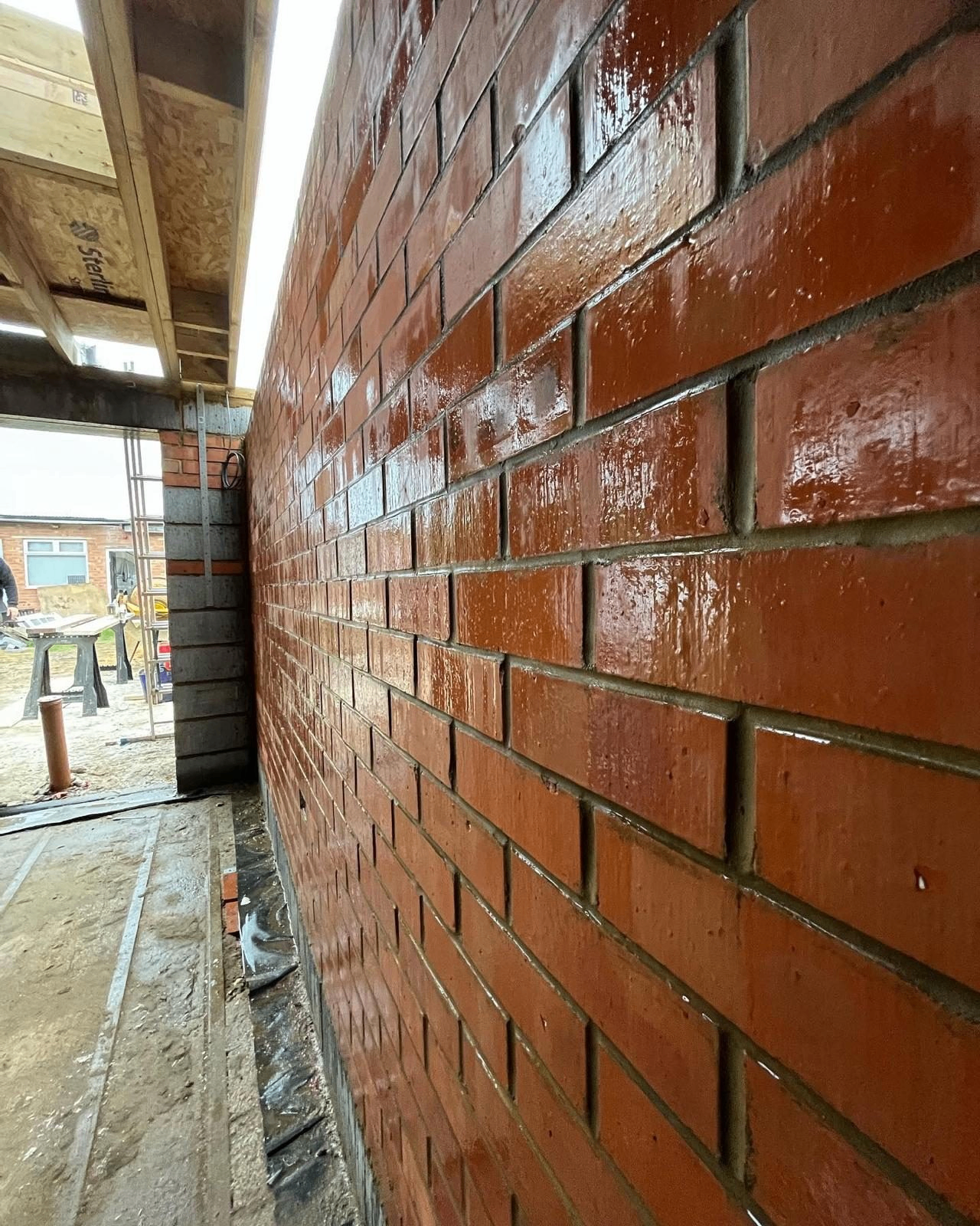 Close-up of wet red brickwork with crisp pointing